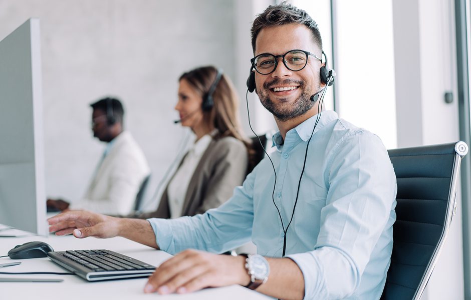 Smiling customer service representative wearing headset at office.